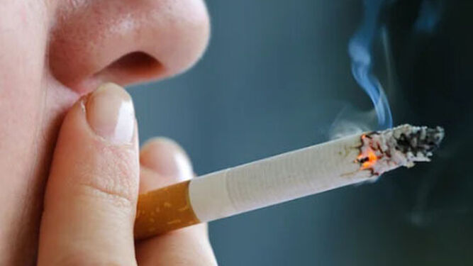 Una persona fuma un cigarro