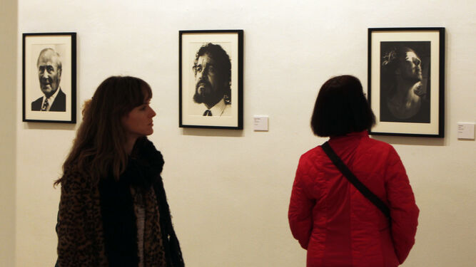 Dos visitantes observan los retratos de Antonio Gálvez a Joan Miró, Mauro Mejíaz y Mechtilt